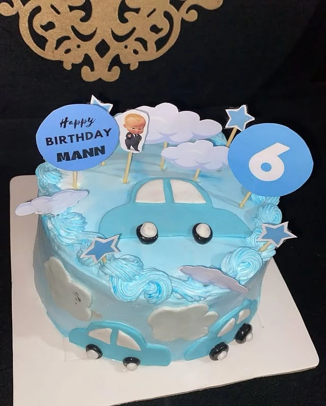 6-month baby car theme cake with 'Happy Birthday Mann' message and vehicle decorations - Baby Car Theme Cakes Karachi By Whisk And Sift